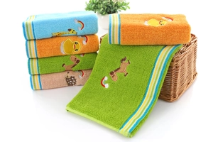 Close-up of soft cotton kids towels with cute animal embroidery in a woven basket
