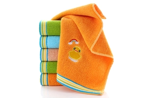 Detailed macro view of soft cotton children towels with colorful embroidery and textures
