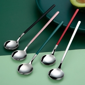 Five long-handled 304 stainless steel spoons in assorted colors on a green background