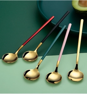 Macro view of five 304 stainless steel dessert spoons with multi-colored handles on a plate