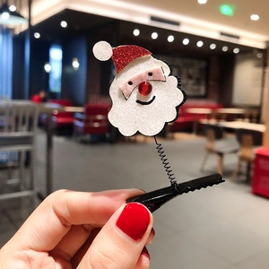 Close-up of Santa Claus spring hair clip with red sequin hat on a metal crocodile clip