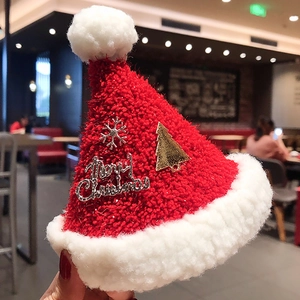 Detailed close-up of soft red plush Christmas hat hair clip with festive pins