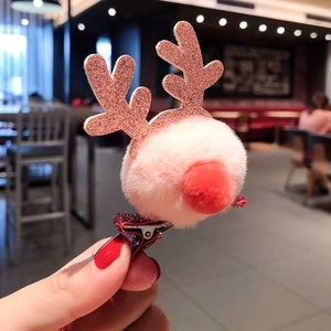 Close-up of pink pom-pom reindeer hair clip with brown glitter antlers and red nose