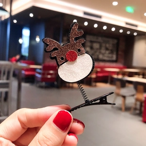 Detail of Christmas reindeer hair clip with brown glitter antlers and red nose on spring