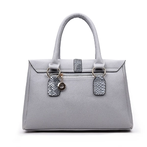 Macro detail of grey litchi grain faux leather handbag with snake pattern accents