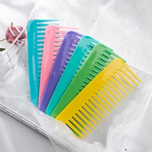 Five colorful plastic wide-tooth hair combs for detangling in a white mesh basket