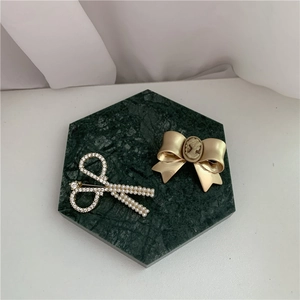Baroque bow brooch with gold portrait cameo and pearl scissors pin on marble base