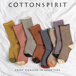 Classic striped cotton mid-calf socks in various retro colors on white linen fabric