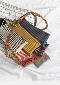 Close-up of assorted colorful striped cotton socks with ribbed cuffs in a metal basket