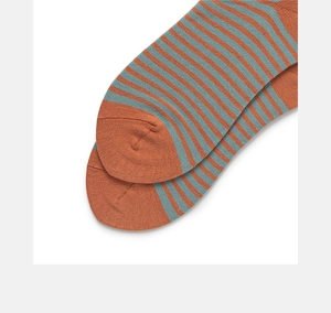 Close-up of ribbed cotton crew socks with orange and grey-blue horizontal stripes