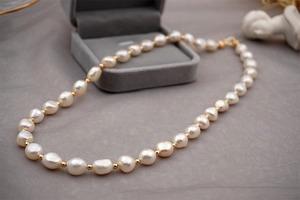 Detailed macro view of baroque freshwater pearl necklace with golden spacer beads