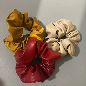 Three pieces of elegant PU leather scrunchies in yellow, red, and beige colors