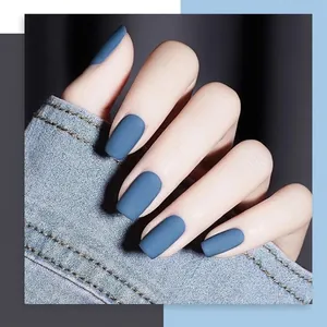 Vernis à ongles mat bleu cyan B18 sur main avec manche en jean pour un look stylé