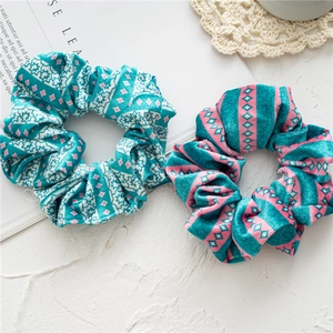 Detail of teal corduroy Christmas scrunchies with snowflake patterns and soft texture