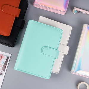 Flat lay of macaron color PU leather binder journals with pens and stationery accessories