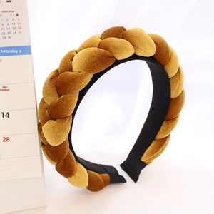 Close-up of golden velvet braided headband showing rich texture and woven details