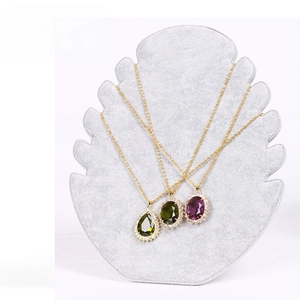 Grey velvet flame display stand with gemstone drop necklaces in gold and purple finish