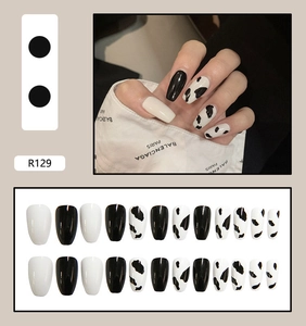 Detailed view of long square cow print press-on nails with 24-piece full set layout