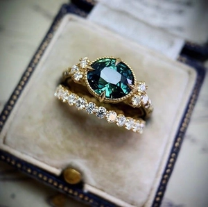 Elegant gold ring set with oval green gemstone and zircons in a velvet gift box