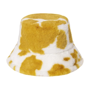 Vue détaillée de la texture pelucheuse et du motif de vache jaune sur ce chapeau bob en fourrure