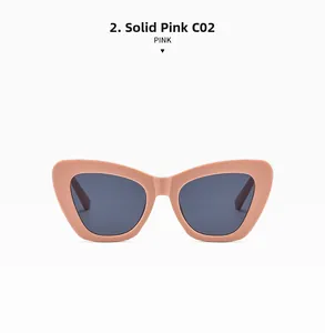Close-up detail of oversized pink cat-eye sunglasses with solid pink frames and dark lenses