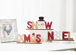 Three-piece wooden Christmas signs featuring Snowman, Santa, and Noel on a white table