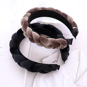 Detail of woven velvet braided headbands in black and brown over white fabric