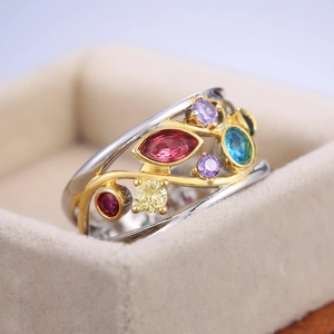 Close-up of a silver ring with gold vine accents and colorful marquise gemstones