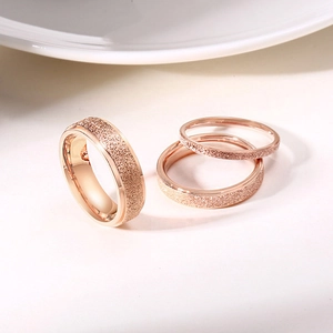 Three-piece rose gold ring set with glitter frost finish on polished stainless steel