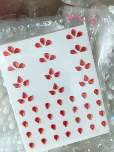 Close-up of red teardrop rhinestones on white backing for eye makeup and DIY art