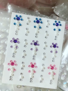 Detailed view of floral rhinestone stickers with blue pink and purple gems and pearls