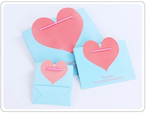 Three sizes of light blue paper gift bags featuring large pink heart and rope handles