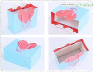 Detail view of pink heart-shaped design on light blue gift bag with woven rope handles