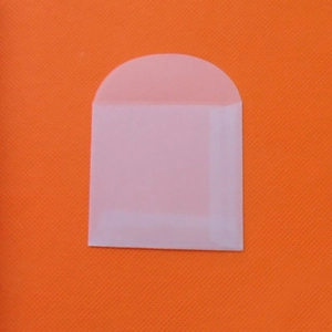 Blank translucent tracing paper envelope with round flap on orange textured background