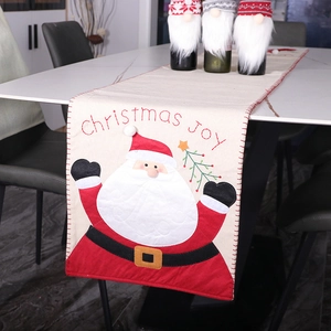 Christmas table runner with Santa Claus embroidery and Christmas Joy text on a dining table