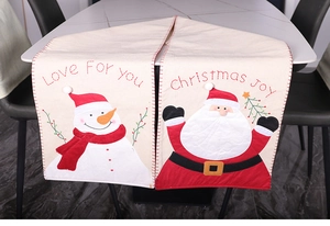 Detail of Santa Claus embroidery and festive pom-poms on a 180cm Christmas table runner