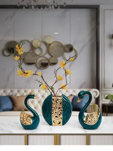 Détail de cygnes décoratifs en céramique vert foncé avec des finitions dorées