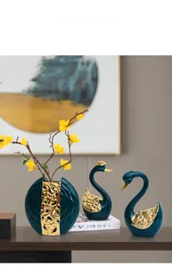 Détails de cygnes en céramique vert foncé et vase avec des accents de feuilles dorées