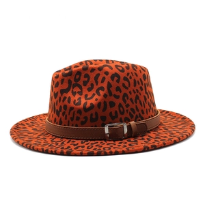 Détail d'un chapeau fedora léopard avec bande en cuir marron et boucle argentée en métal
