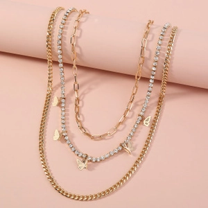 Close-up of layered gold butterfly necklace and sparkling rhinestone tennis chain