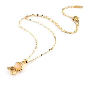 Close-up of golden Buddha pendant with orange stone inlay on a polished chain