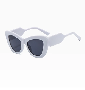 Macro shot of white cat-eye sunglasses with wide temple design and dark grey lenses