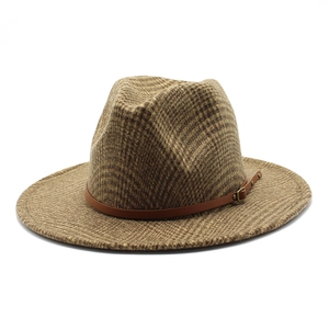 Close-up of houndstooth wool fedora hat with brown leather band and bronze buckle