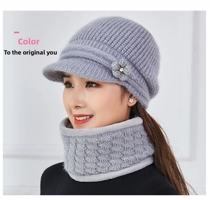 Detail of light grey knitted winter hat with floral accent and matching neck gaiter