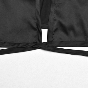 Close-up of black satin crop top featuring a criss-cross lace-up back detail