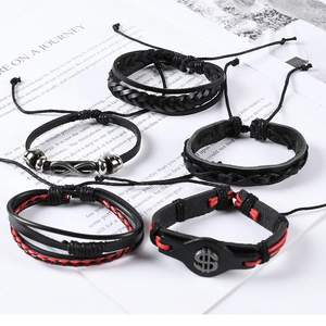 Detail view of 5-piece black leather bracelet set with infinity and dollar sign charms