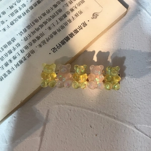 Detail of five cute resin bears hair clip with glitter gradient on a white surface