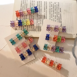 Close-up of colorful laser cute bear hair clips with transparent gradient acrylic texture