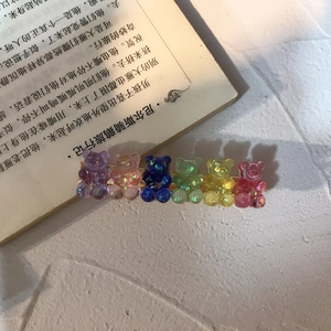 Detail of colorful resin gummy bear hair clips with glitter on a golden metal base