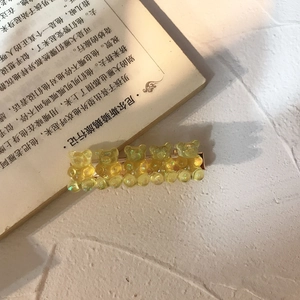 Detail of yellow glitter bear hair clips with jelly texture on a metal barrette
